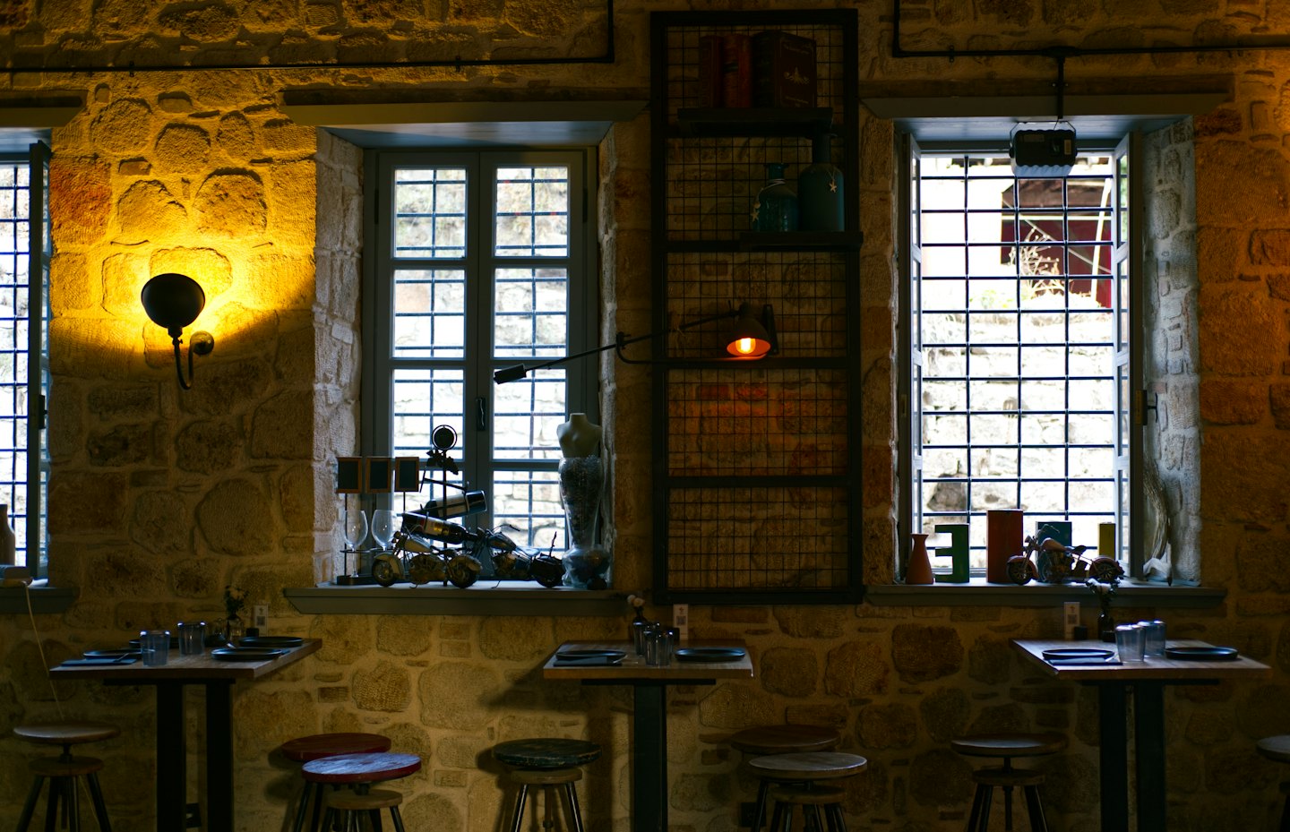 Interno di un ristorante rustico con muri in pietra e tavoli in legno.